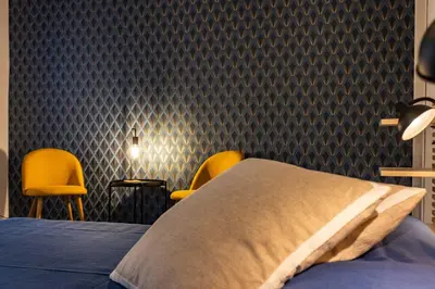 a bedroom with a bed and two yellow chairs at Finestre sul Massimo - Centro Storico Palermo in Palermo