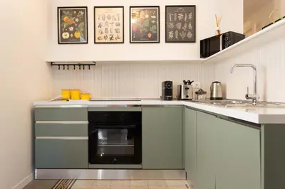 a kitchen with green cabinets and a sink at Finestre sul Massimo - Centro Storico Palermo in Palermo