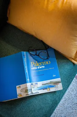 a pair of glasses sitting on top of a book at Finestre sul Massimo - Centro Storico Palermo in Palermo