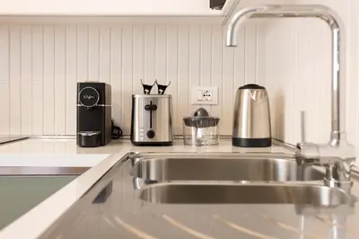 a kitchen with a stainless steel sink and appliances at Finestre sul Massimo - Centro Storico Palermo in Palermo
