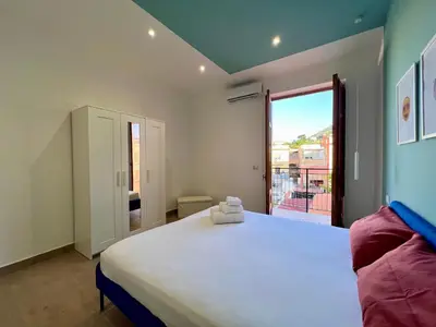 a bedroom with a large bed and a large window at GiraSole in Palermo