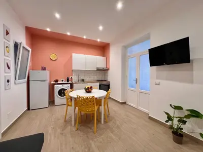 a kitchen and dining room with a table and chairs at GiraSole in Palermo