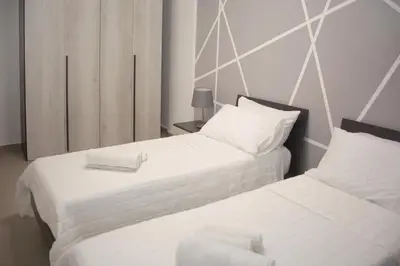 two beds in a hotel room with white sheets at Montalcini 3 in Capaci