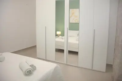 a white room with a mirror and a bed at Montalcini 3 in Capaci