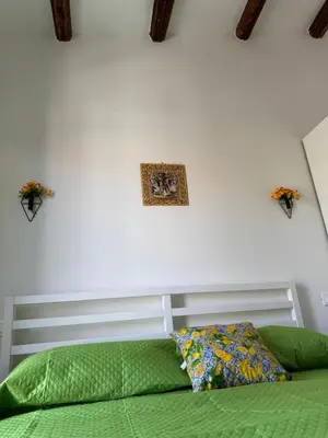 a bedroom with a green bed and a picture on the wall at Corte Panormus in Palermo