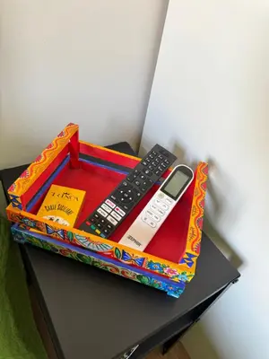 a box with two remote controls and a cell phone on a table at Corte Panormus in Palermo