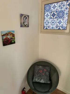 a green chair with a pillow in a room with tiles at Corte Panormus in Palermo