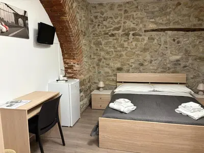 a bedroom with a bed and a desk with a desk at Cortili Himeresi in Termini Imerese