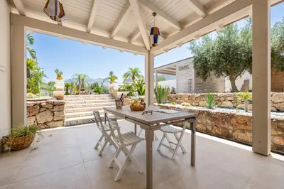 a patio with a table and chairs and a stone wall at 14th Oasis Family Room In Villa With Pool Near Palermo in Carini