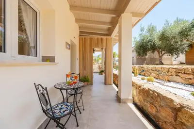 a patio with a table and chairs and a stone wall at 14th Oasis Family Room In Villa With Pool Near Palermo in Carini