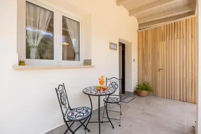 a patio with a table and chairs and a window at 14th Oasis Villa With Private Pool Near Palermo in Carini