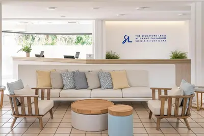 a living room with a couch and chairs at Grand Palladium Sicilia Resort & Spa in Campofelice di Roccella