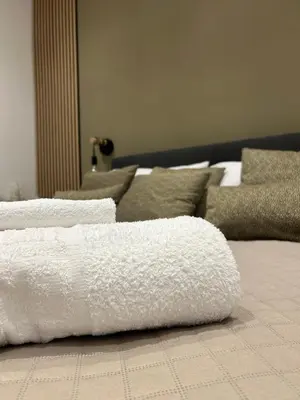 a pile of white towels sitting on a bed at Beta Suite in Palermo