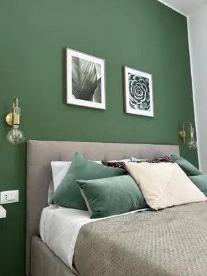 a bedroom with a bed with green walls at Beta Suite in Palermo