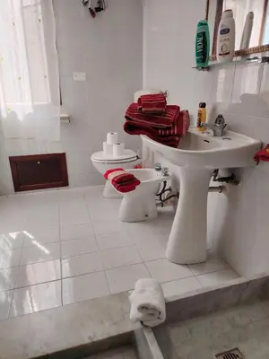 a white bathroom with a sink and a toilet at ClimaDerna SX Climatizzata in Castellammare del Golfo