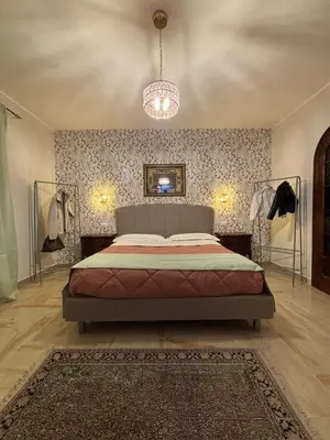 a bedroom with a bed and a chandelier at Grand Holiday Home Namarì in Palermo