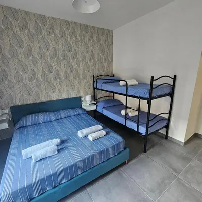 a bedroom with two bunk beds and a blue rug at Hakuna matata in Terrasini