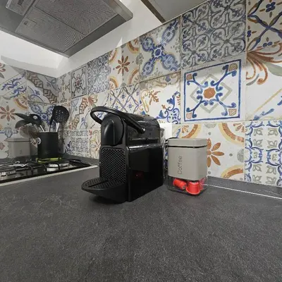 a kitchen with blue and white tiles on the wall at Hakuna matata in Terrasini