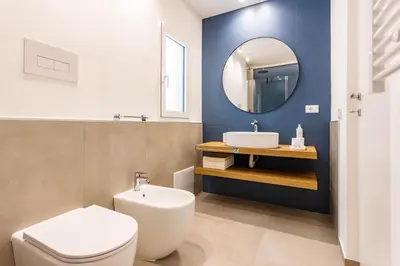 a bathroom with a toilet and a sink and a mirror at Capo D'Amuri in Palermo