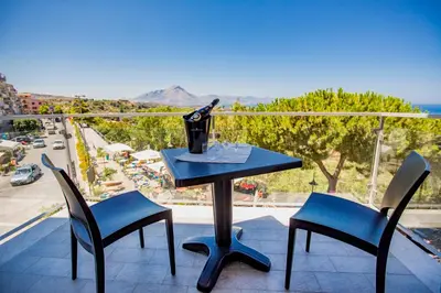 a table and chairs on a balcony with a view at Belvedere Rent Rooms in Campofelice di Roccella