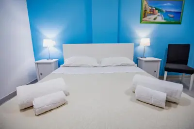 a bedroom with a large white bed with two chairs at Belvedere Rent Rooms in Campofelice di Roccella