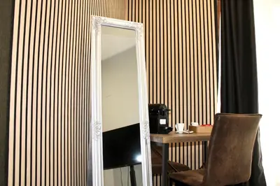 a mirror in a room with a table and a chair at Rooms, eleganza moderna nel centro storico di Palermo in Palermo