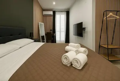 a bedroom with a large bed with towels on it at Rooms, eleganza moderna nel centro storico di Palermo in Palermo