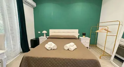 a bedroom with a bed with two towels on it at Rooms, eleganza moderna nel centro storico di Palermo in Palermo