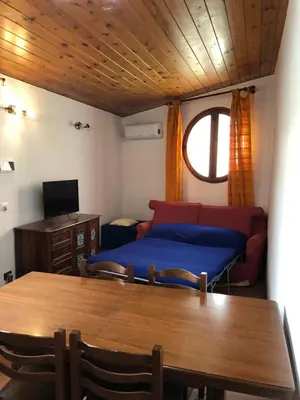 a living room with a bed and a table and a window at Casetta Mondello in Mondello