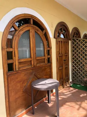 a stool sitting in front of a wooden door at Casetta Mondello in Mondello