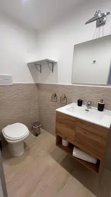 a bathroom with a white sink and a toilet at Amuní Holiday House in Cinisi