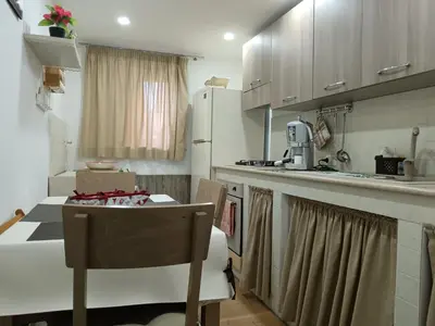 a small kitchen with a table and a refrigerator at La casa di Marió in Palermo