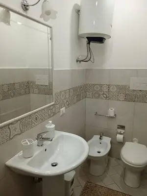a bathroom with a sink and a toilet and a mirror at La casa di Marió in Palermo