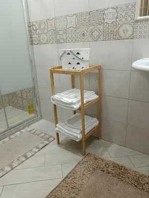 a bathroom with a sink and a shelf with towels at La casa di Marió in Palermo