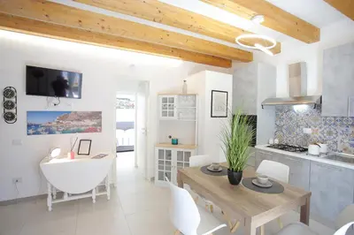 a kitchen and living room with a table and a dining room at Airport Palace Cinisi in Cinisi