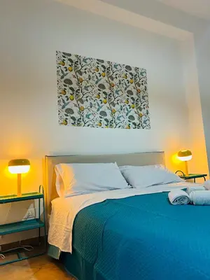 a bedroom with a blue bed with two lamps at Mercede rooms Ballaró in Palermo