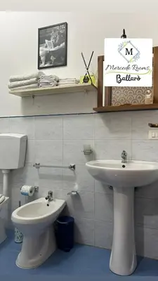 a bathroom with a white sink and a toilet at Mercede rooms Ballaró in Palermo