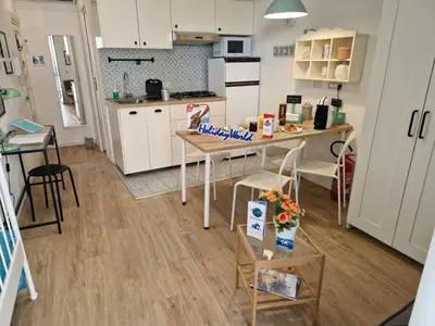 a kitchen with white cabinets and a table and chairs at Come a Casa by Holiday World in Palermo