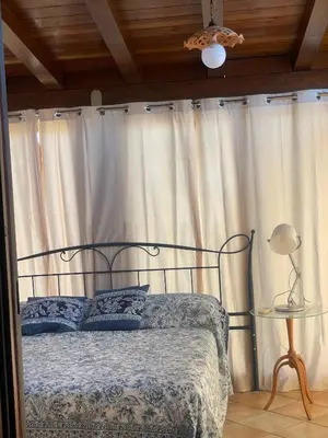 a bedroom with a bed with a wrought iron headboard at La casetta dei limoni in Santa Flavia