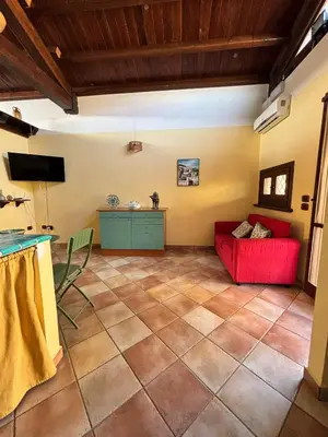 a living room with a red couch and a table at La casetta dei limoni in Santa Flavia