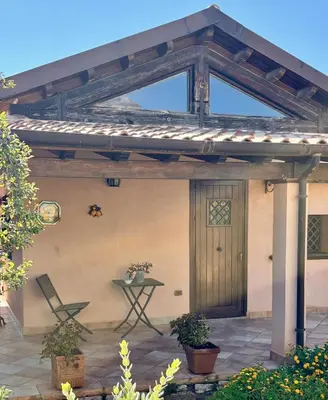 a wooden pergola with a table and a chair on a patio at La casetta dei limoni in Santa Flavia
