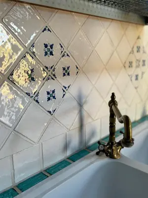 a bathroom sink with a faucet on a tiled wall at La casetta dei limoni in Santa Flavia