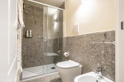 a bathroom with a shower and a toilet and a sink at Turrisi Apartment in Palermo