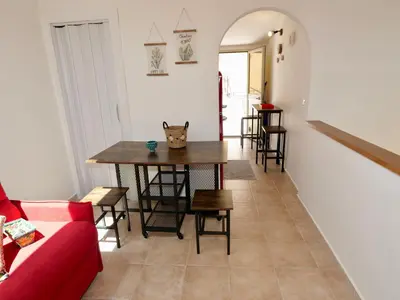 a living room with a table and a red couch at Casetta al Duomo in Monreale