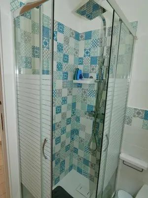 a bathroom with a shower with blue and white tiles at Casetta al Duomo in Monreale