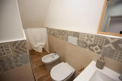 a bathroom with a toilet and a sink and a mirror at Holiday House Annunziata 1 in Termini Imerese