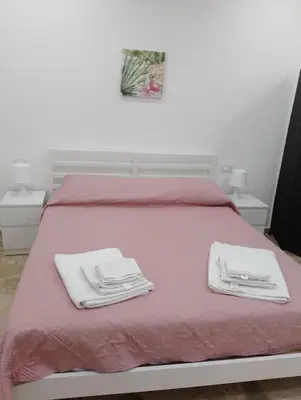 a bed with white towels sitting on top of it at Holiday House Annunziata 1 in Termini Imerese
