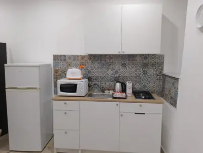 a kitchen with white cabinets and a microwave on a counter at Holiday House Annunziata 1 in Termini Imerese