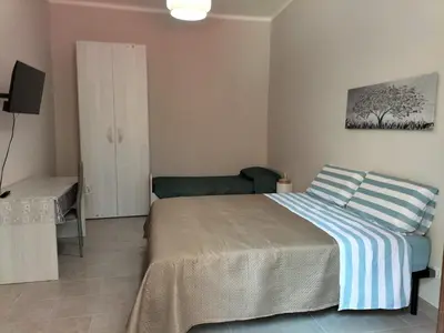 a bedroom with a bed and a couch at Casa Verdi in Capaci