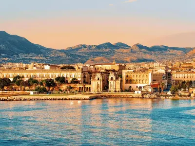 a city on the water with mountains in the background at Il Fico d'India by Holiday World in Palermo
